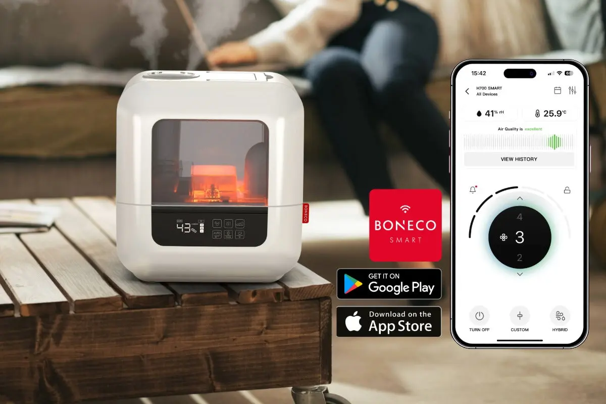 hvit luftfukter på bord i stue med app på mobiltelefon ved siden av
